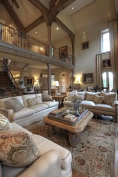 a living room filled with lots of furniture and a stair case in the middle of it