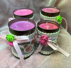 four candles with ribbons and flowers on them