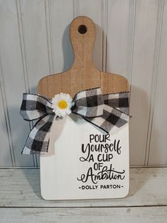 a wooden cutting board with a sign that says pour yourself a cup of artisan dolly patron