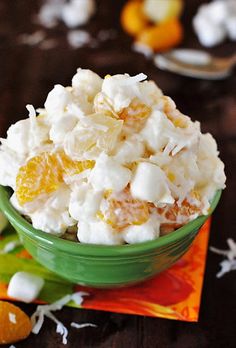 a green bowl filled with white and orange popcorn