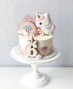 there is a cake decorated with unicorns and rainbows