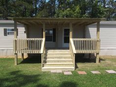 a mobile home with stairs leading up to the front door and second story porch area