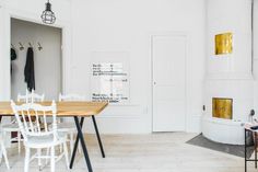 a dining room table and chairs in front of a white wall with gold foil on it