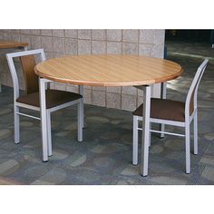 a table and two chairs in front of a brick wall with tile flooring on it