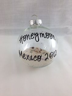 a glass ornament with the words honeymoon mexico 2013 written on it and sand inside