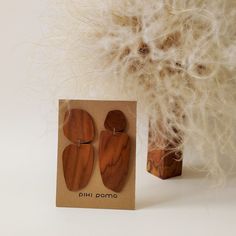 a pair of wooden earrings sitting on top of a card