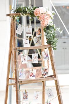 a wooden ladder with pictures and flowers on it