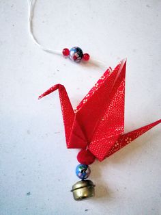 an origami bird with bells attached to it