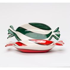 three pieces of green, red and white dishes on top of each other in the shape of fish