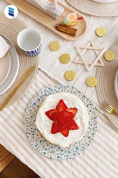 a table topped with plates and bowls filled with food next to strawberries on top of each plate