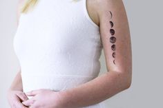 a woman with a tattoo on her left arm and half moon tattoos on her right arm