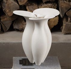 a white vase sitting on top of a stack of books