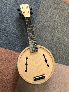 a small wooden instrument sitting on top of a carpeted floor next to a rug