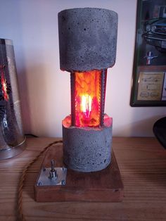 a lit candle is sitting in a concrete holder