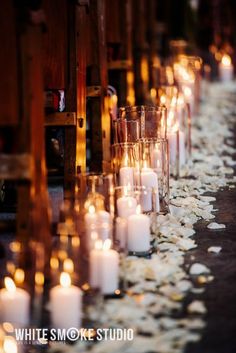 rows of candles are lined up along the aisle