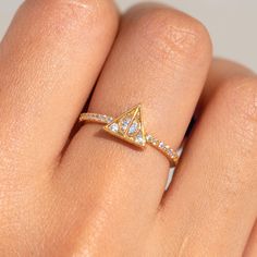 a woman's hand with a diamond ring on her left hand, and a gold band