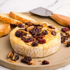 bread with raisins and other toppings sitting on a plate next to some bread