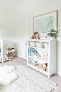 a white book shelf with books and stuffed animals on it in a child's room