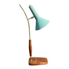 a desk lamp with a wooden base and a blue shade on the top, against a white background