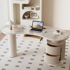 a laptop computer sitting on top of a desk next to a white shelf with shelves