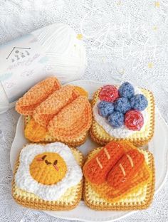 four crocheted food items on a plate next to a bottle of milk and yarn