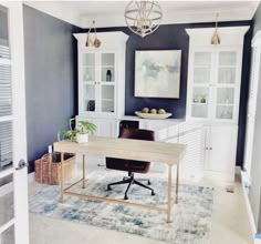 a home office with blue walls and white cabinetry in the corner, along with a rug on the floor