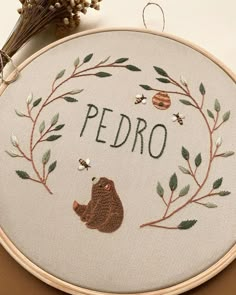 there is a cross stitch pattern on the hoop with words pedro and a bear