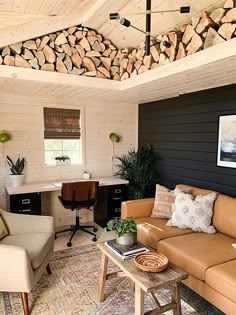 a living room filled with furniture and lots of firewood stacked on the wall above it