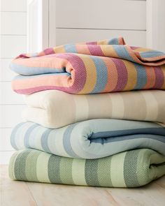 four folded blankets stacked on top of each other