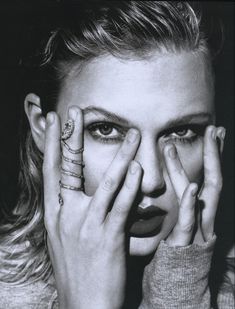 a black and white photo of a woman holding her hands to her face with both hands