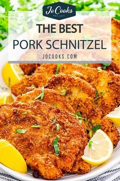 the best pork schnitzel recipe on a plate with lemons and parsley