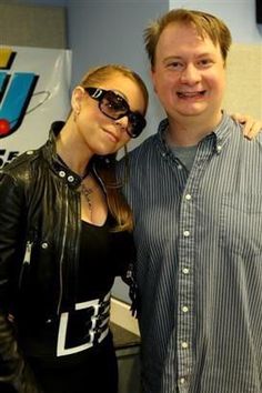 a man standing next to a woman wearing sunglasses