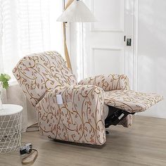 a recliner chair sitting on top of a hard wood floor next to a lamp