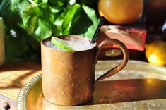 a copper mug with a straw in it sitting on a tray