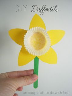 a paper flower being held up to show the size it is cut out and placed on top of