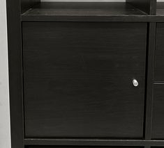 a black cabinet with two drawers and a clock on top