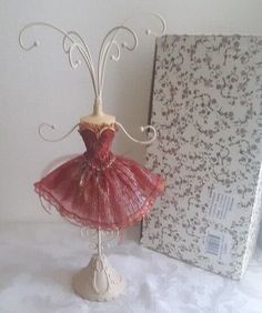 there is a small doll in a dress on a stand