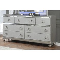 a silver dresser with mirrored drawers in a room