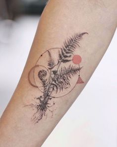 a tattoo on the arm of a person with a fern and moon in it's center