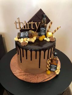 a birthday cake with chocolate icing and candies on top, sitting on a table