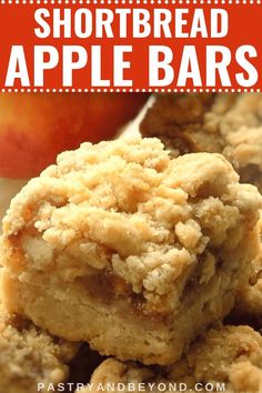 shortbread apple pie bars stacked on top of each other with an apple in the background