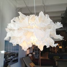 a large white chandelier hanging from the ceiling in a room with couches