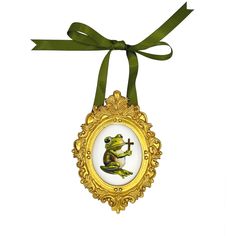 a frog ornament hanging from a green ribbon