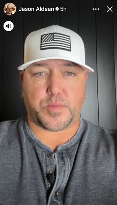 a man wearing a baseball cap with an american flag on the front and back of his hat