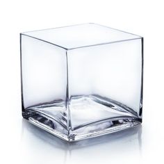 an empty square glass vase sitting on top of a white surface with water in it