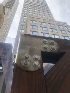 there is a metal object with buttons on it in front of a tall building that has many windows