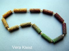 several beads are arranged in the shape of an arrow on a blue background with words vera kerst