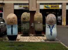 five fake heads in the shape of people's heads on display outside a building