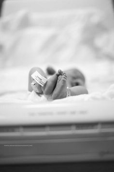 a baby laying in a crib holding a bottle