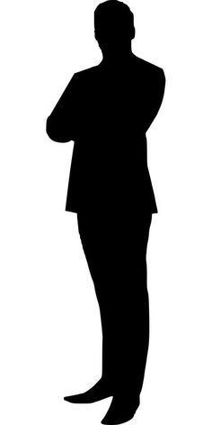 the silhouette of a man in a suit standing with his arms crossed and looking down